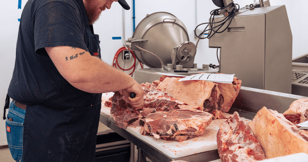 butcher cutting premium meat for local Wichita, Kansas residents.